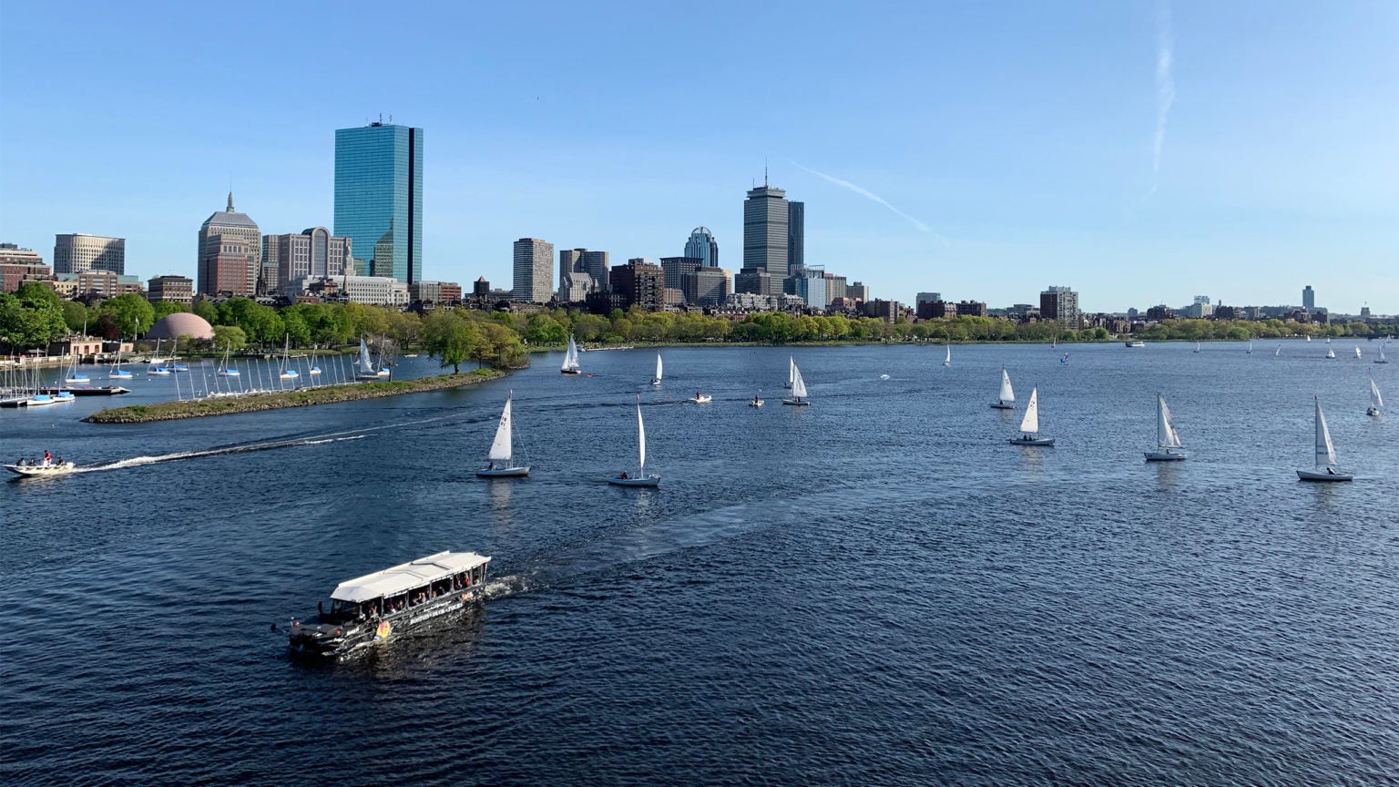 The Charles River with sailboats on the water and the Boston skyline in the background