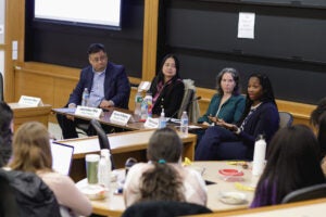 Four panelists speaking in a classroom setting