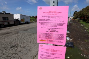 Notices to vacate encampment on signpost.